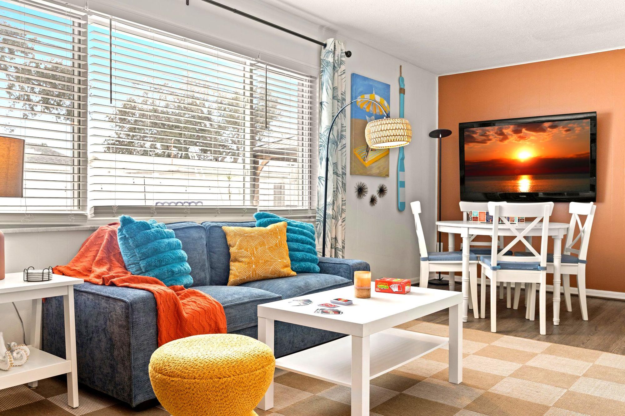 Bright coastal living room at Sunset Escape with a sunset scene on the smart TV