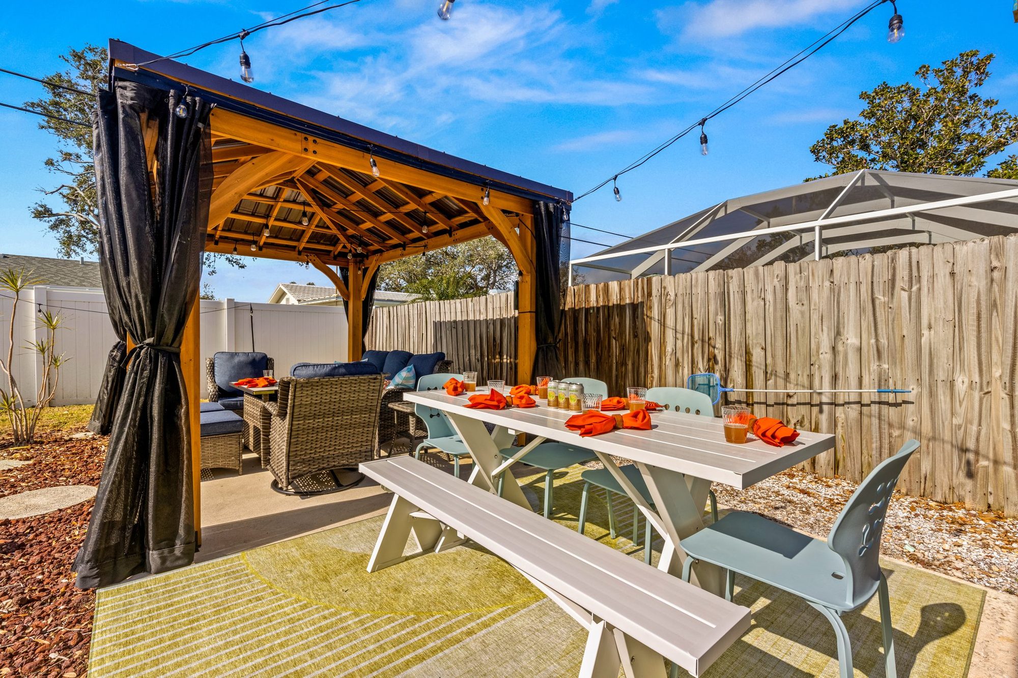 Sunset Escape private heated pool with a cedar pergola, lounge seating, and string lights in Largo, Florida